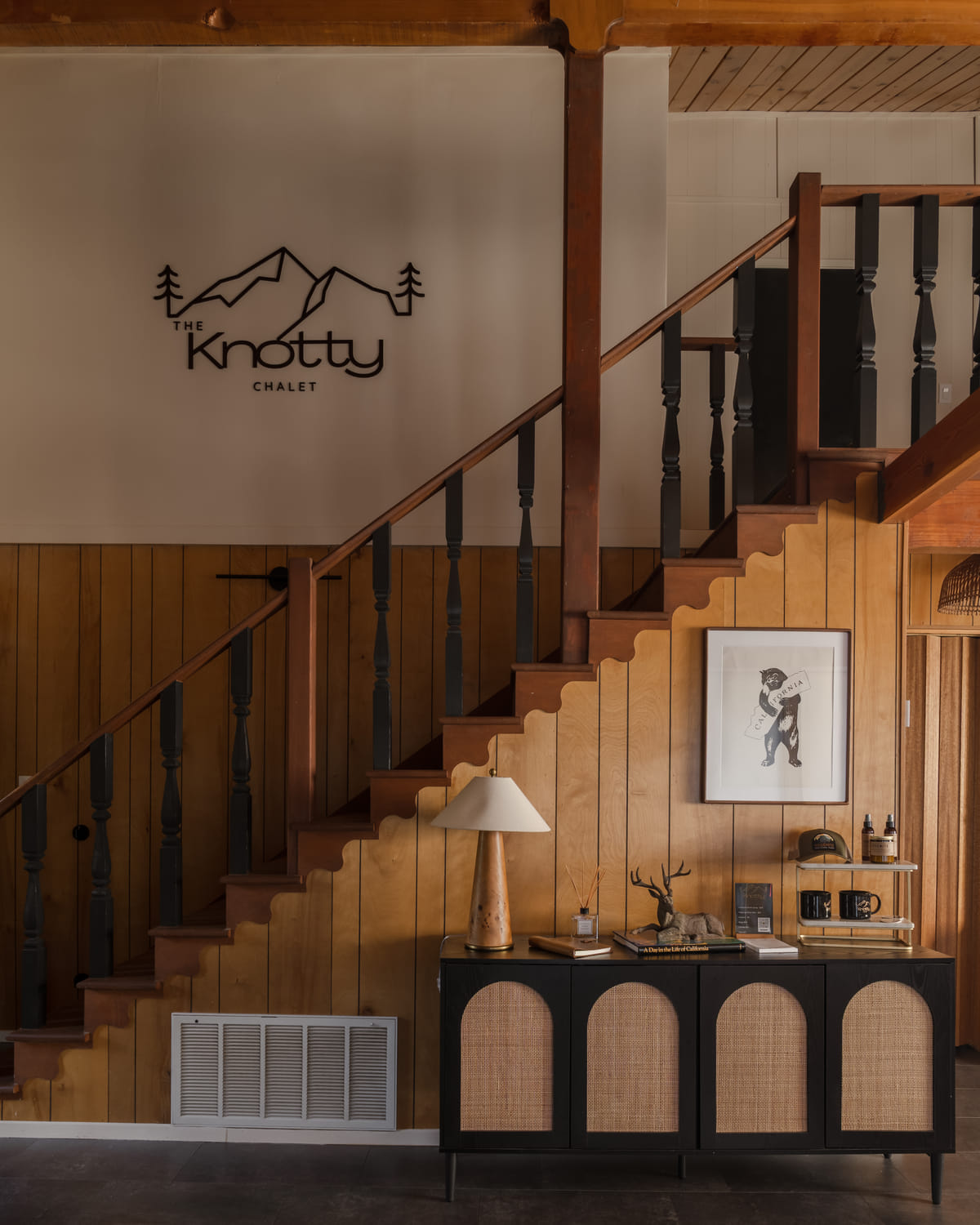 The foyer with the Knotty Chalet sign and the stair