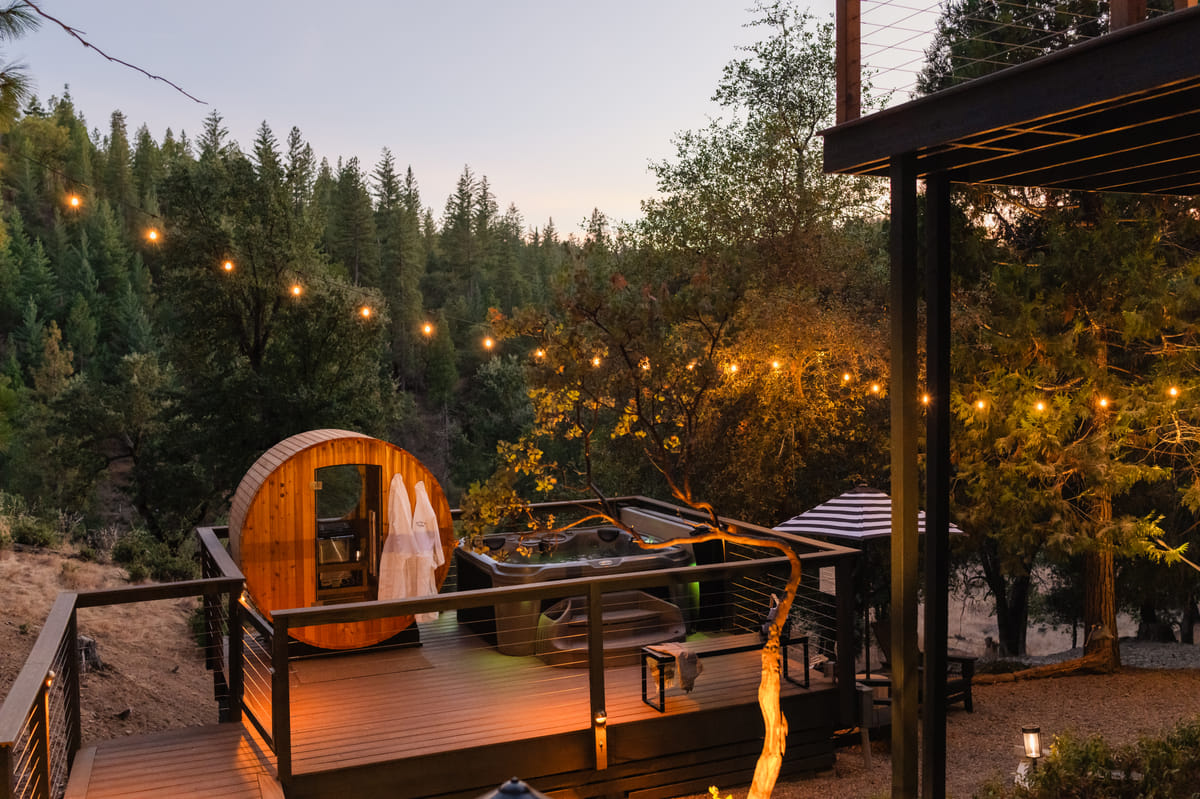 The sauna deck at dusk, string lights on